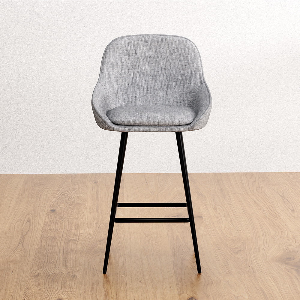 Gray bar stool with black legs on a wooden floor and white wall background