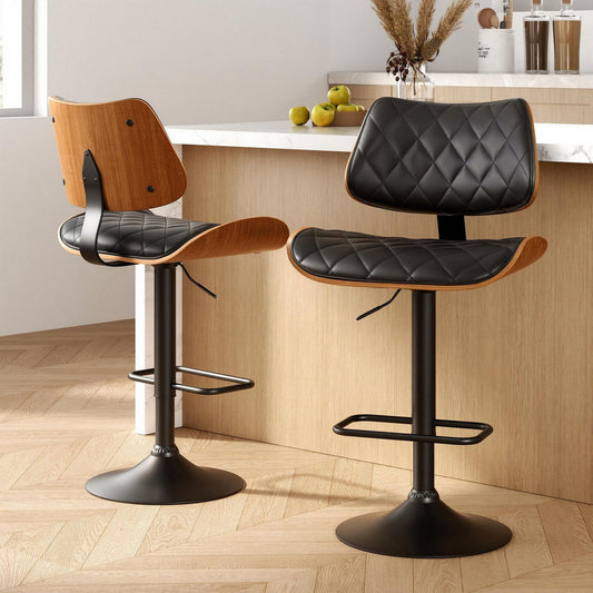 Two bar stools with black leather seats and wooden frames in a kitchen setting