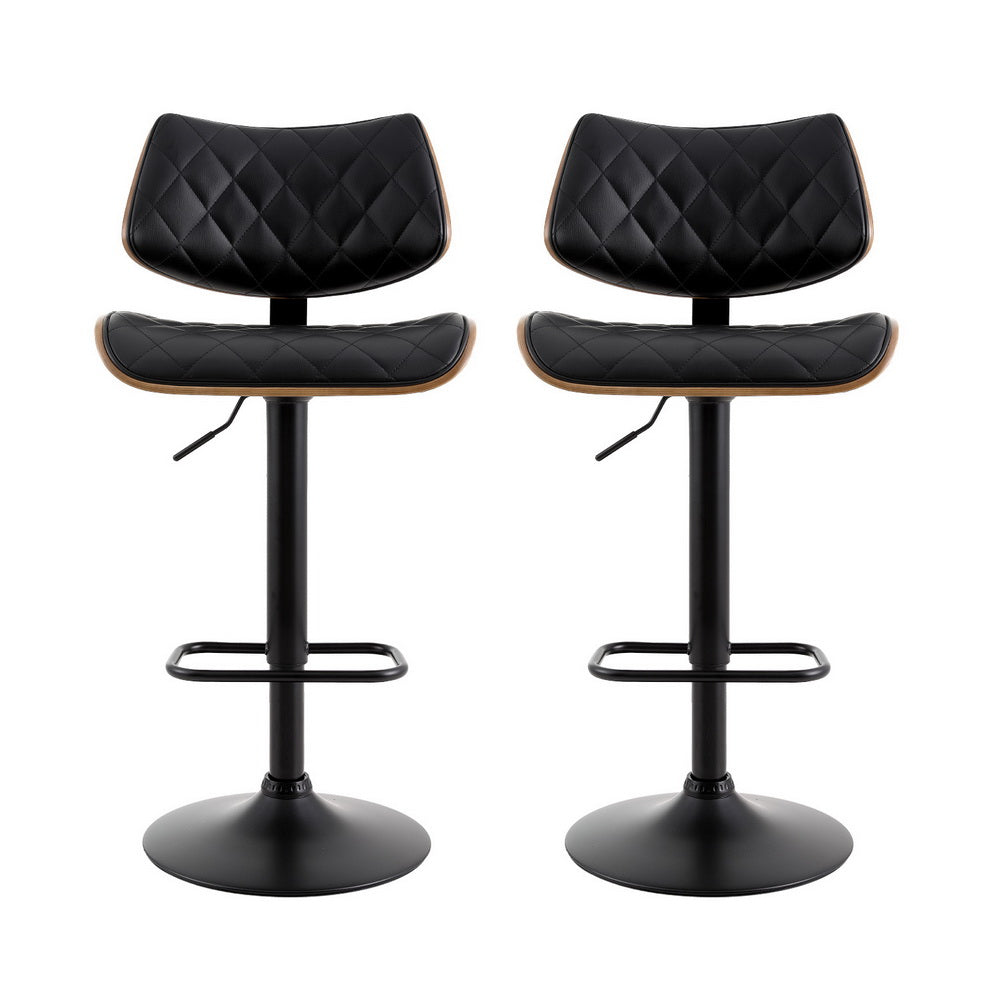 Two black quilted bar stools with wooden seats on a white background