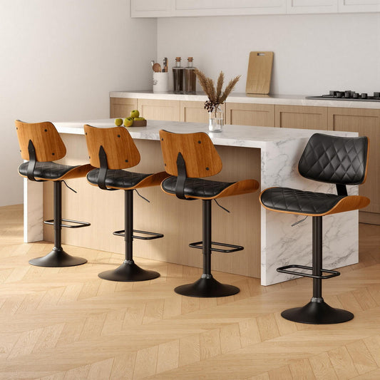 Four bar stools with black leather seats and wooden frames in a kitchen setting