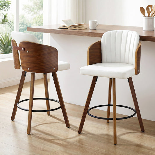 Two wooden bar stools with white cushioned seats in a kitchen setting.
