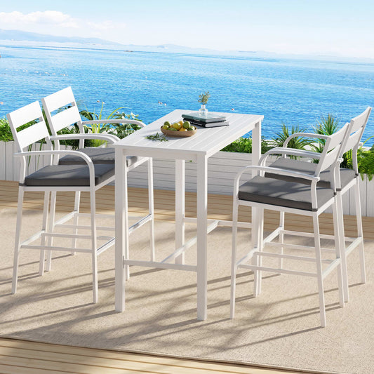 Outdoor dining set with high chairs and table on a deck overlooking the ocean.