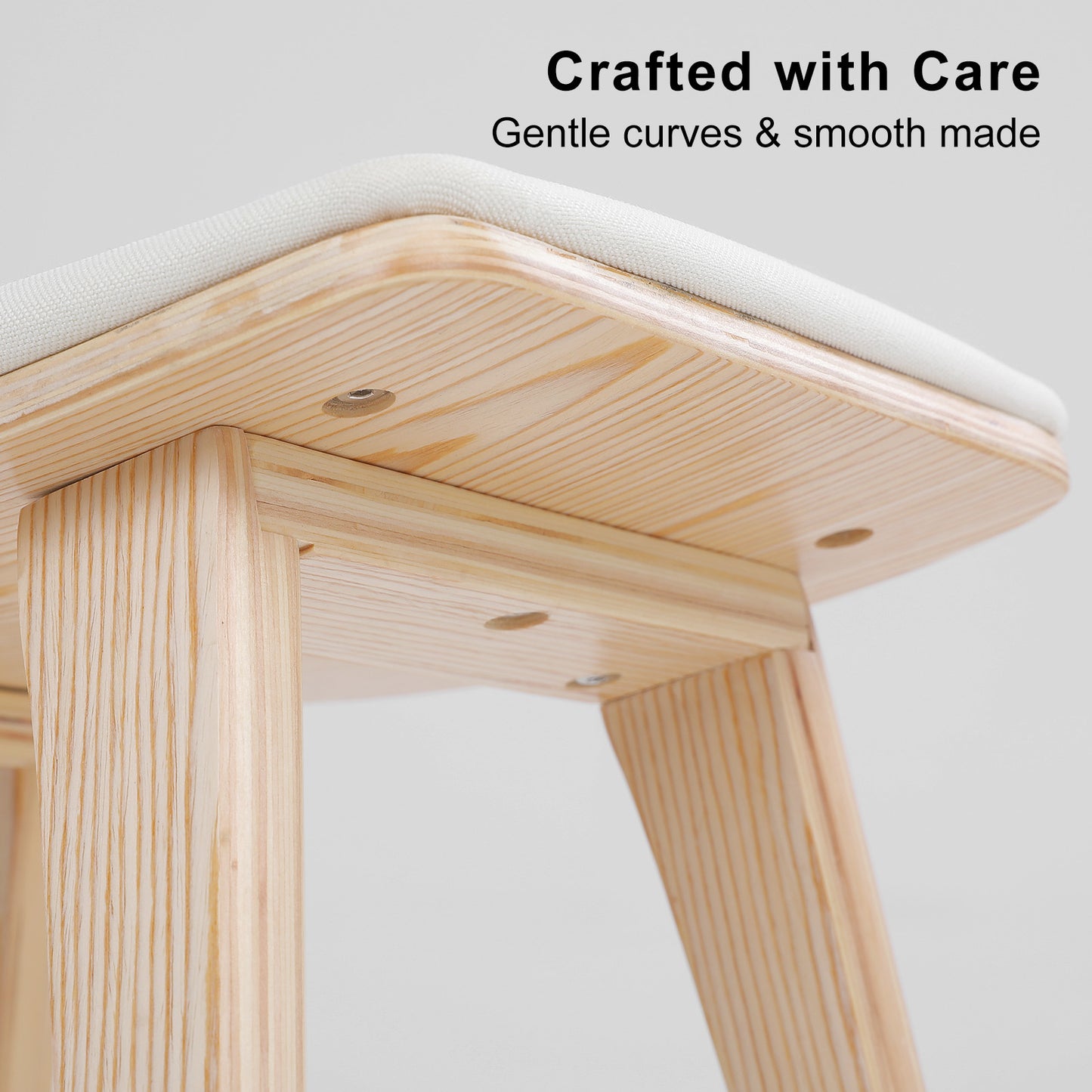 Wooden stool with a white cushioned seat on a light gray background, featuring text 'Crafted with Care' and 'Gentle curves & smooth made'.