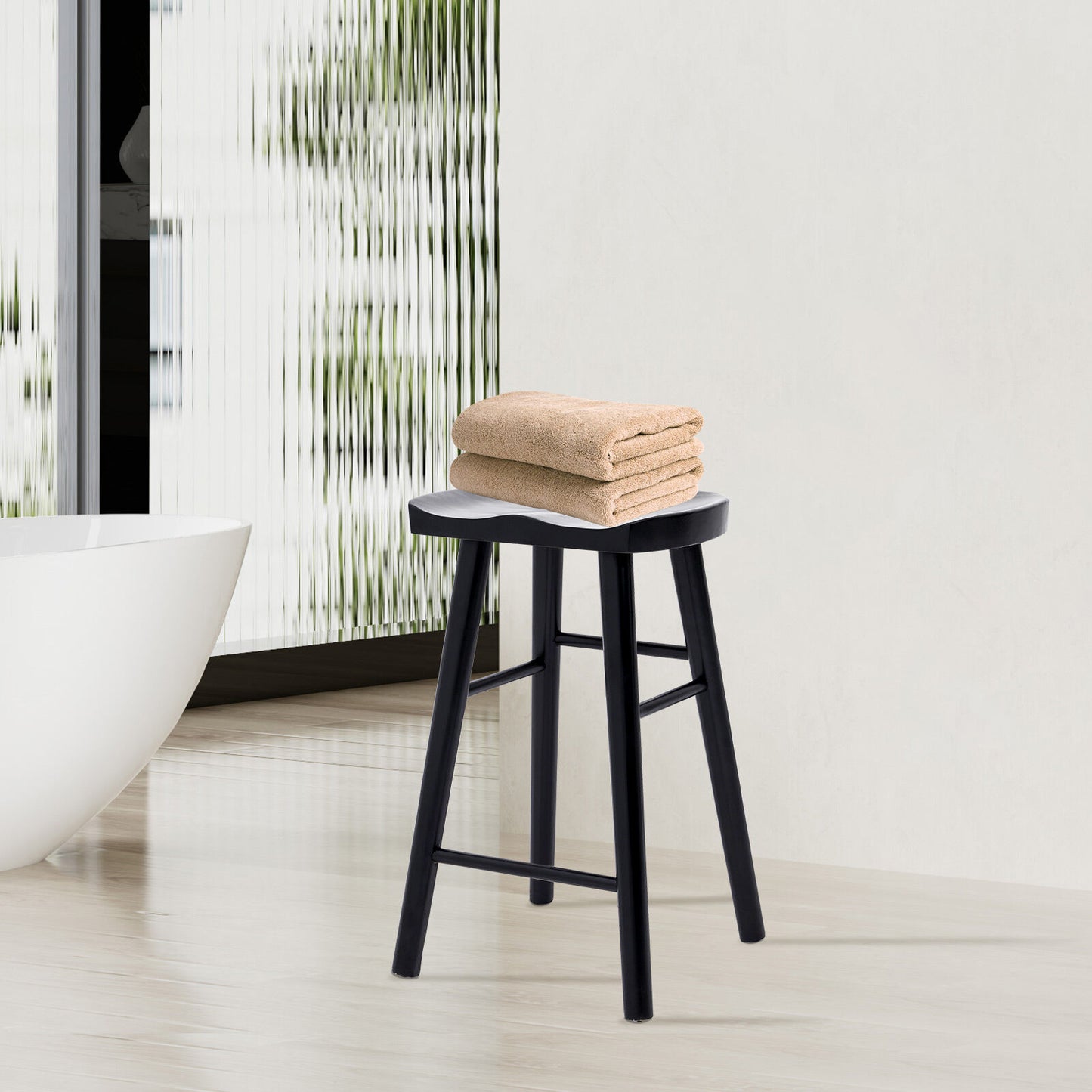 Black stool with folded towels in a bathroom setting