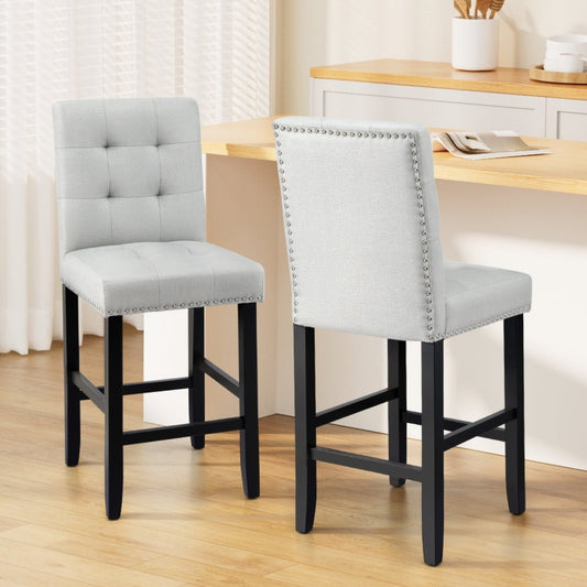 Two grey linen bar stools with black legs in a kitchen setting