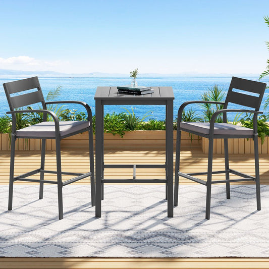 Outdoor patio set with two high chairs and a table on a deck with ocean view.