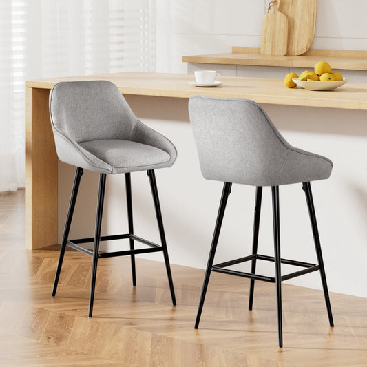 Two gray bar stools with black legs in a kitchen setting.