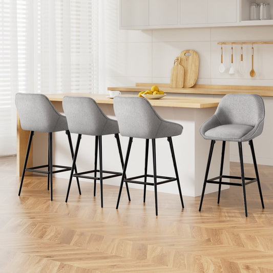 Four gray bar stools with black legs in a kitchen setting.