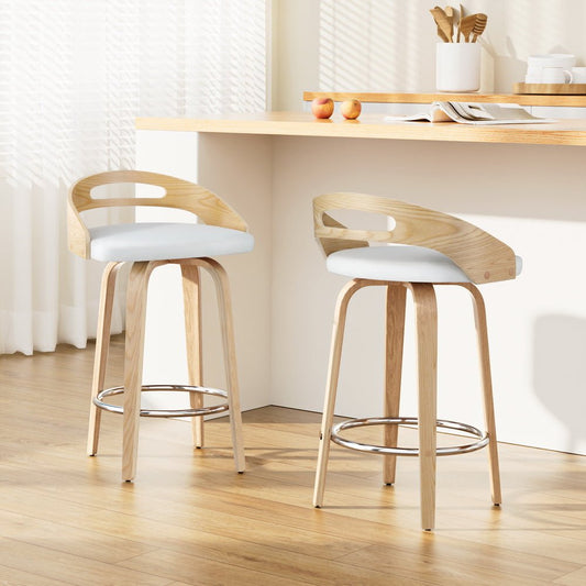 Two wooden bar stools with white seats in a kitchen setting.