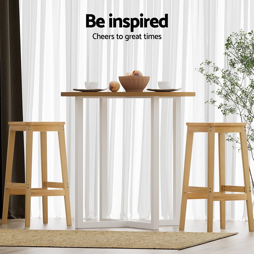 Wooden table with stools and a bowl of fruit against a white curtain background with 'Be inspired' text.