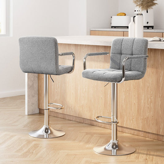 Two grey cushioned bar stools with metal legs in a kitchen setting.