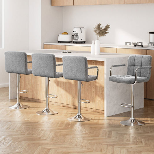 Four gray bar stools in a modern kitchen setting with wooden flooring and cabinets.