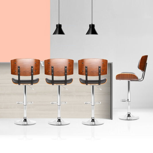 Four wooden bar stools with metal legs on a white floor against a light gray wall.