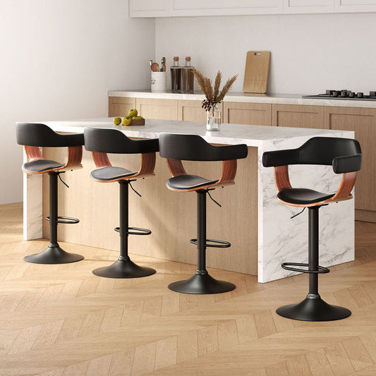 Four black bar stools with wooden seats arranged around a kitchen island.