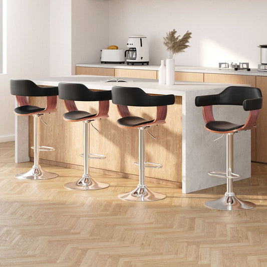 Four black bar stools with wooden seats in a modern kitchen setting.