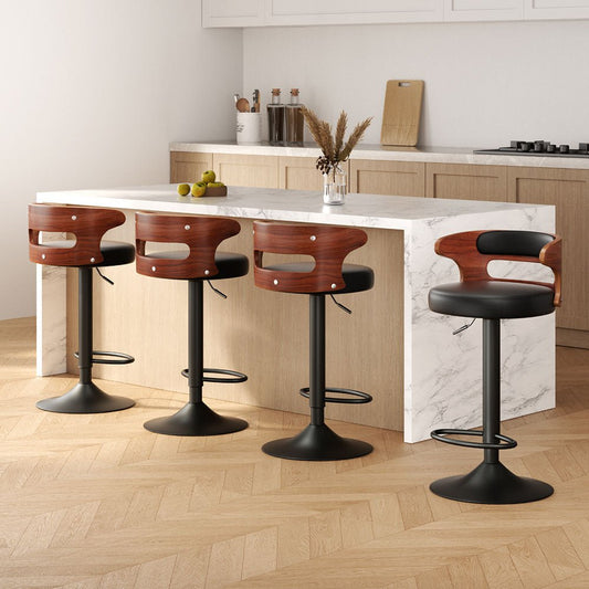 Four bar stools with wooden seats and black bases around a kitchen island.
