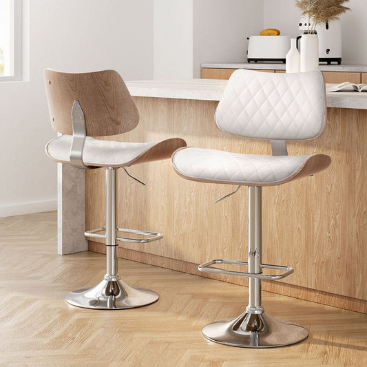 Two bar stools with wooden seats and metal bases in a kitchen setting.