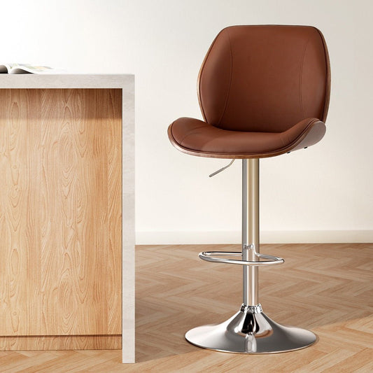 Brown leather bar stool with metal base next to a wooden counter.