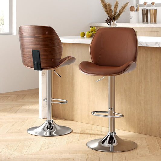 Two brown bar stools with chrome bases in a kitchen setting.