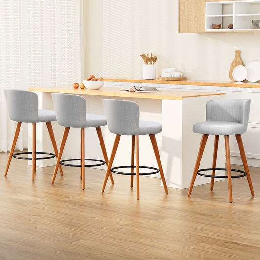 Four grey bar stools with wooden legs around a kitchen island