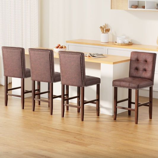 Four brown leather bar stools with nailhead trim around a wooden dining table in a kitchen.