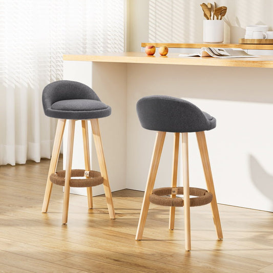Two grey cushioned bar stools with wooden legs in modern kitchen dining counter
