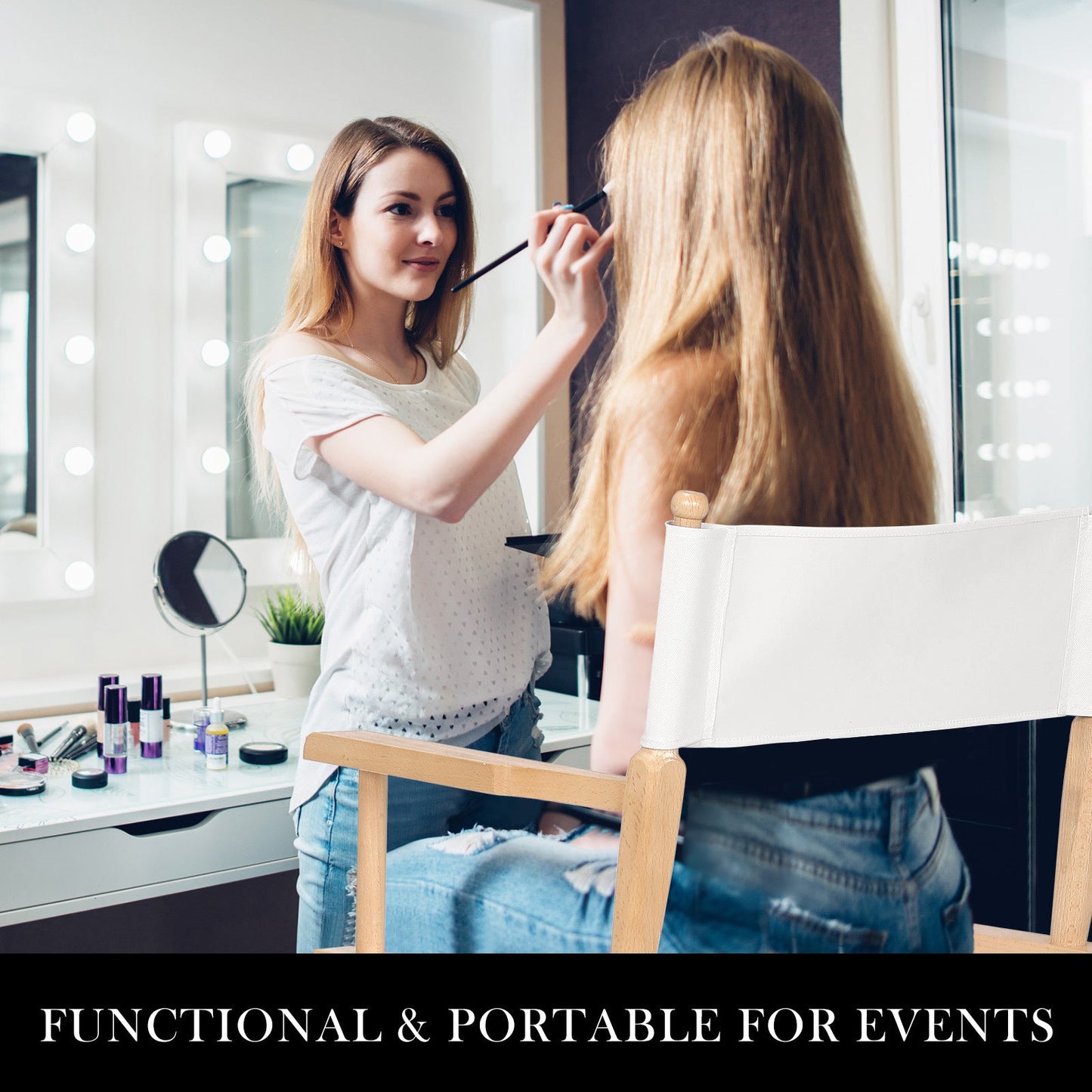 Makeup artist applying makeup to a client seated on a wooden Oxford tall director chair with white canvas seat and backrest in a bright studio setting.