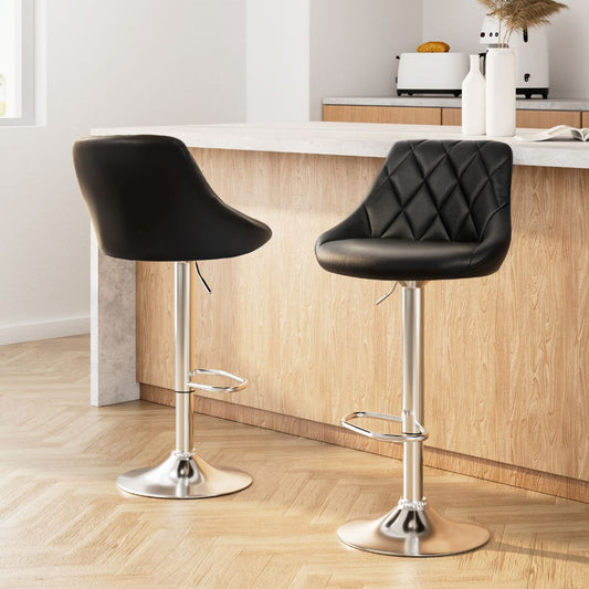 Two black bar stools with chrome legs in a kitchen setting.