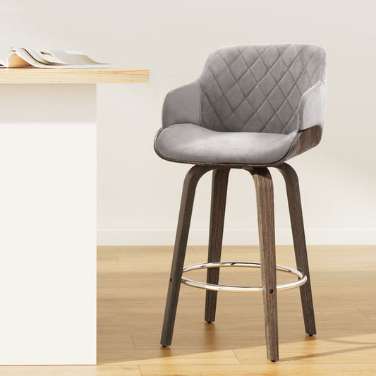 Grey quilted bar stool with wooden legs in a minimalistic setting