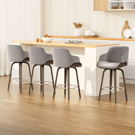 Four grey bar stools with wooden legs around a kitchen island