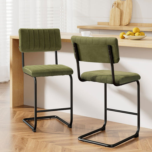 Two green bar stools with black frames in a kitchen setting
