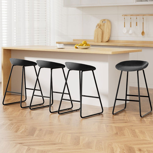 Black bar stools in a kitchen setting with a wooden counter and cutting board.