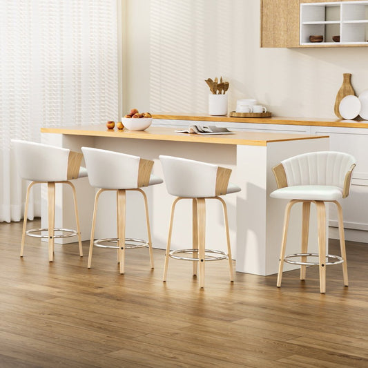 Four white bar stools with wooden legs arranged around a kitchen island.