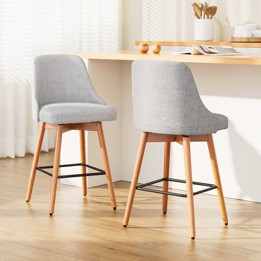Two grey bar stools with wooden legs in a kitchen setting