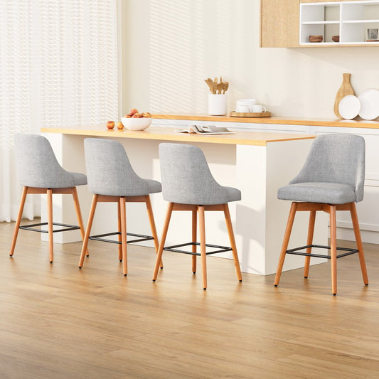 Four grey bar stools with wooden legs around a kitchen island