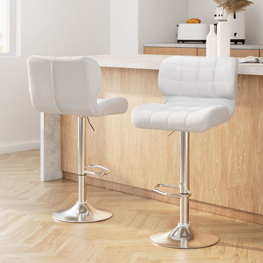 Two white bar stools with chrome bases in a kitchen setting.