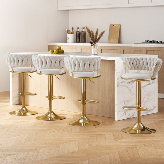 Four white bar stools with gold bases in a kitchen setting.