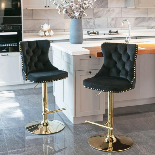 Two black bar stools with gold bases in a modern kitchen