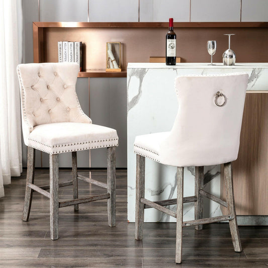 Two bar stools with beige cushioned seats and wooden legs in a room with a counter and wine bottle