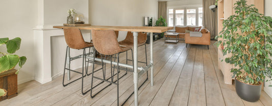 Brown leather bar stools at a kitchen bench in a modern open-plan home
