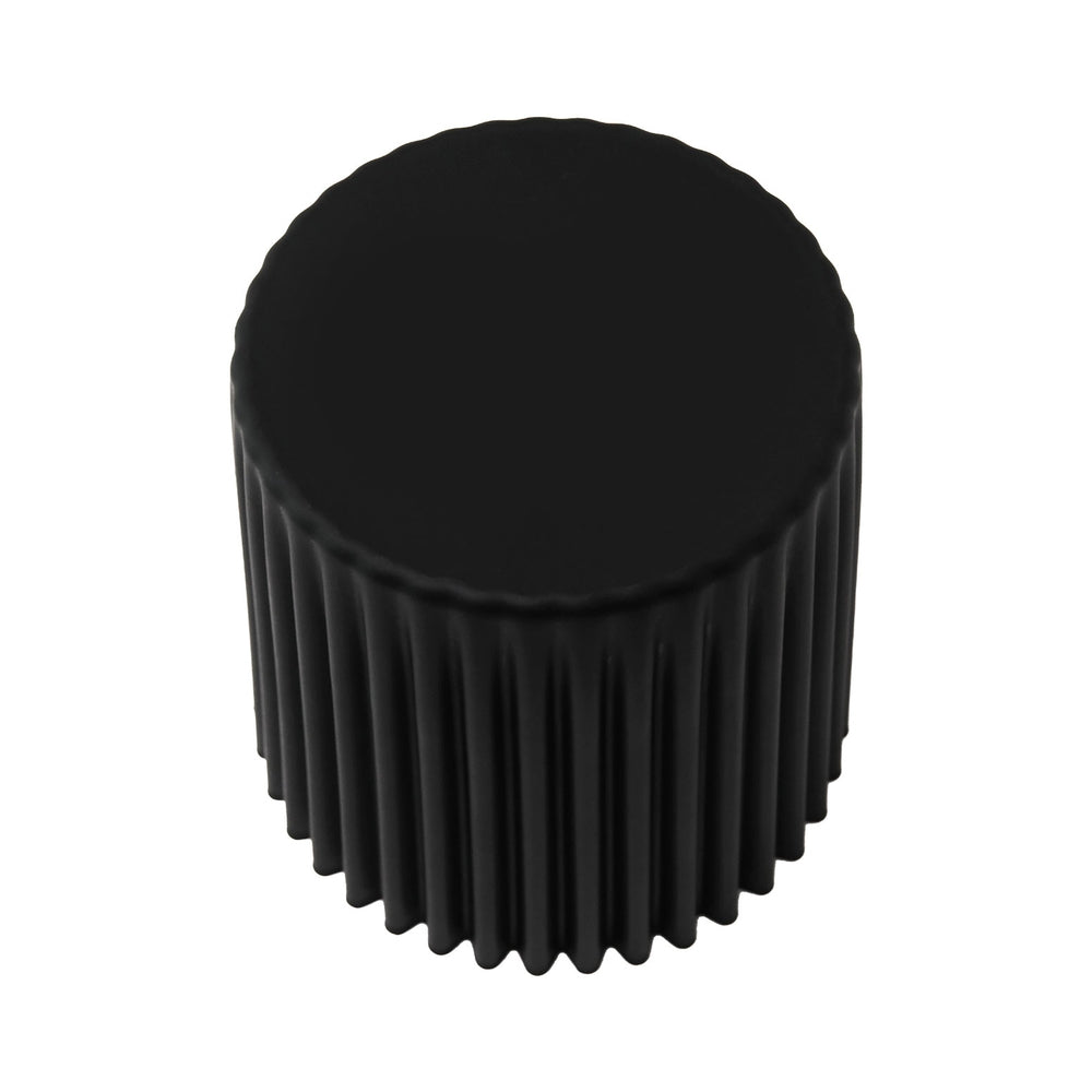 Black cylindrical stool with textured surface on a white background