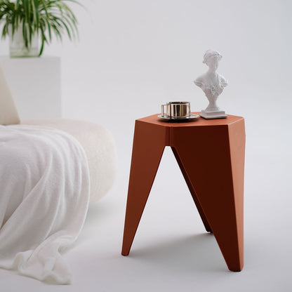 Modern side table with a plant and decorative items in a minimalistic setting