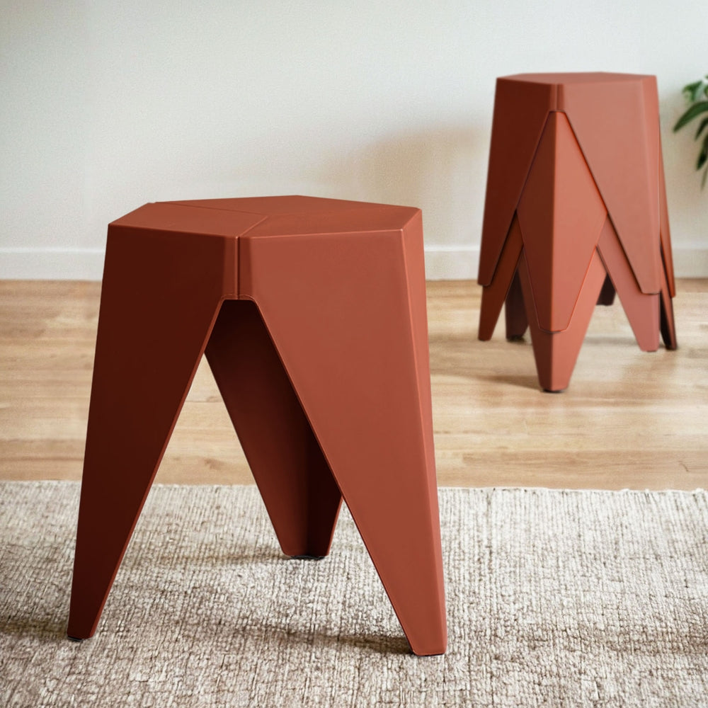 Two modern red stools on a wooden floor with a neutral background