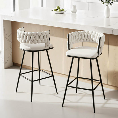 Two white cushioned bar stools with black legs in a modern kitchen setting.