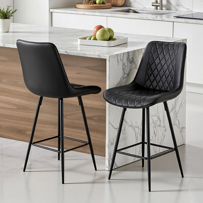 Two black bar stools in front of a kitchen island with marble countertop.