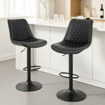 Two black quilted bar stools in a kitchen setting.