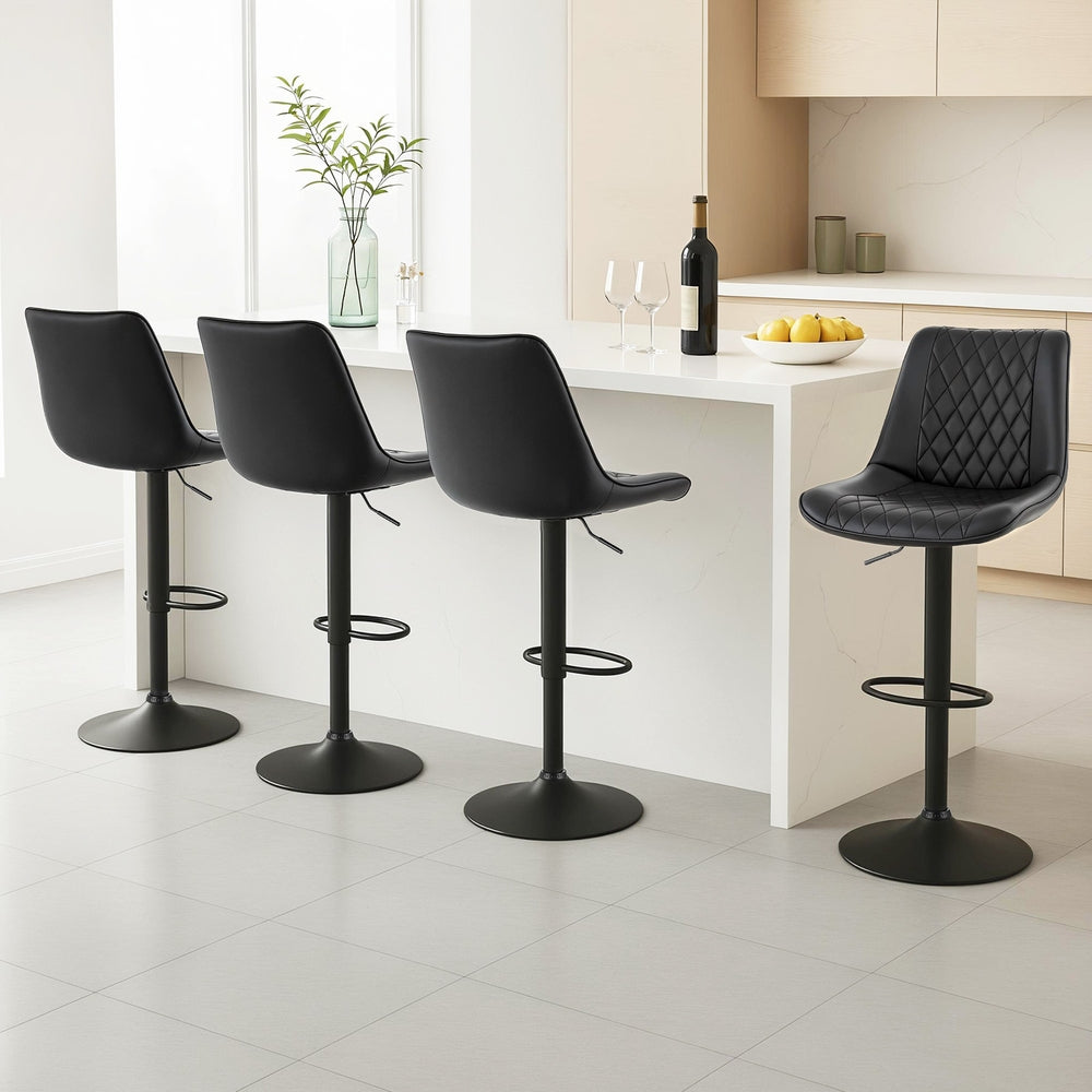 Four black bar stools in a modern kitchen setting.
