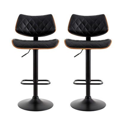 Two black quilted bar stools with wooden accents on a white background