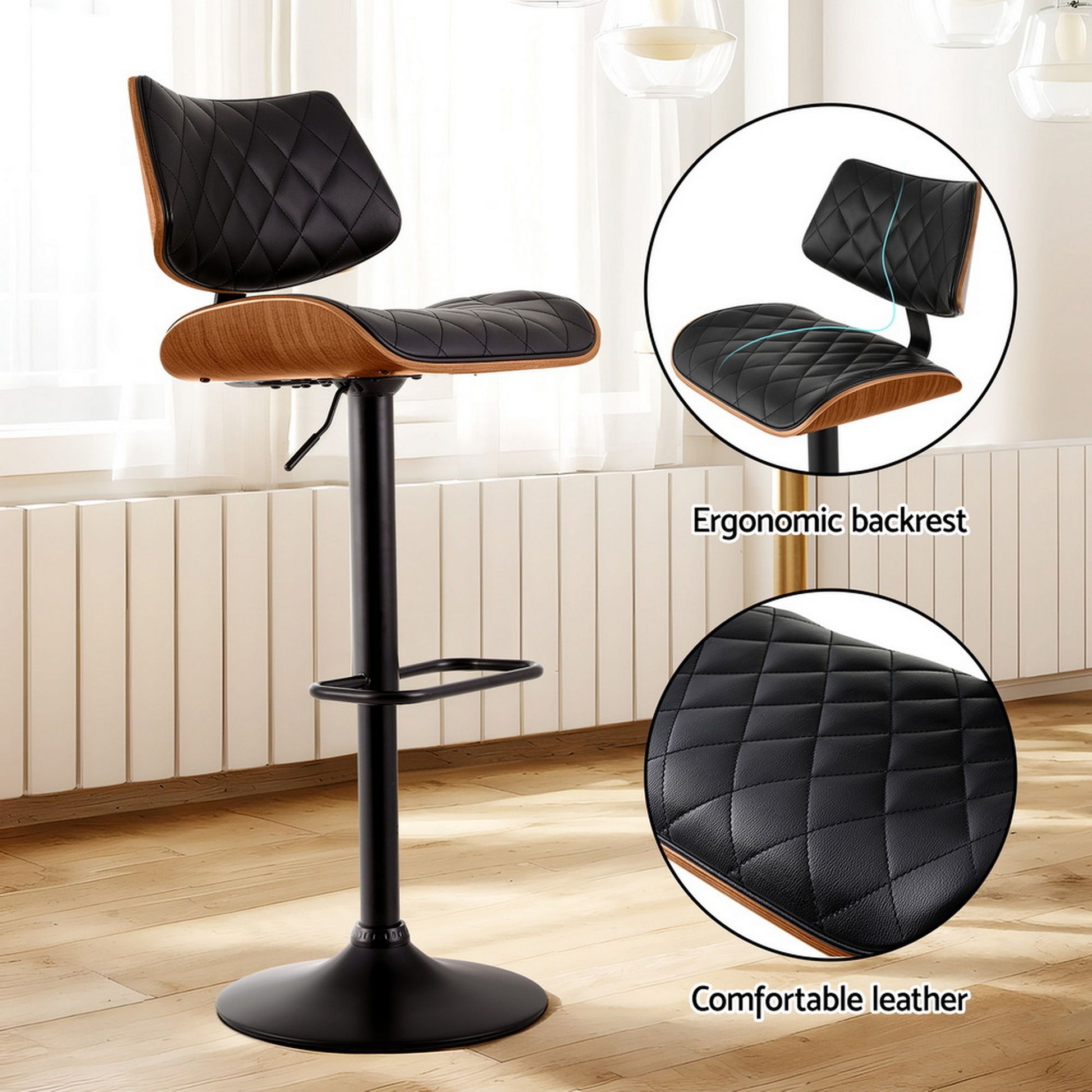 Bar stool with black quilted leather seat and wooden armrests on a wooden floor