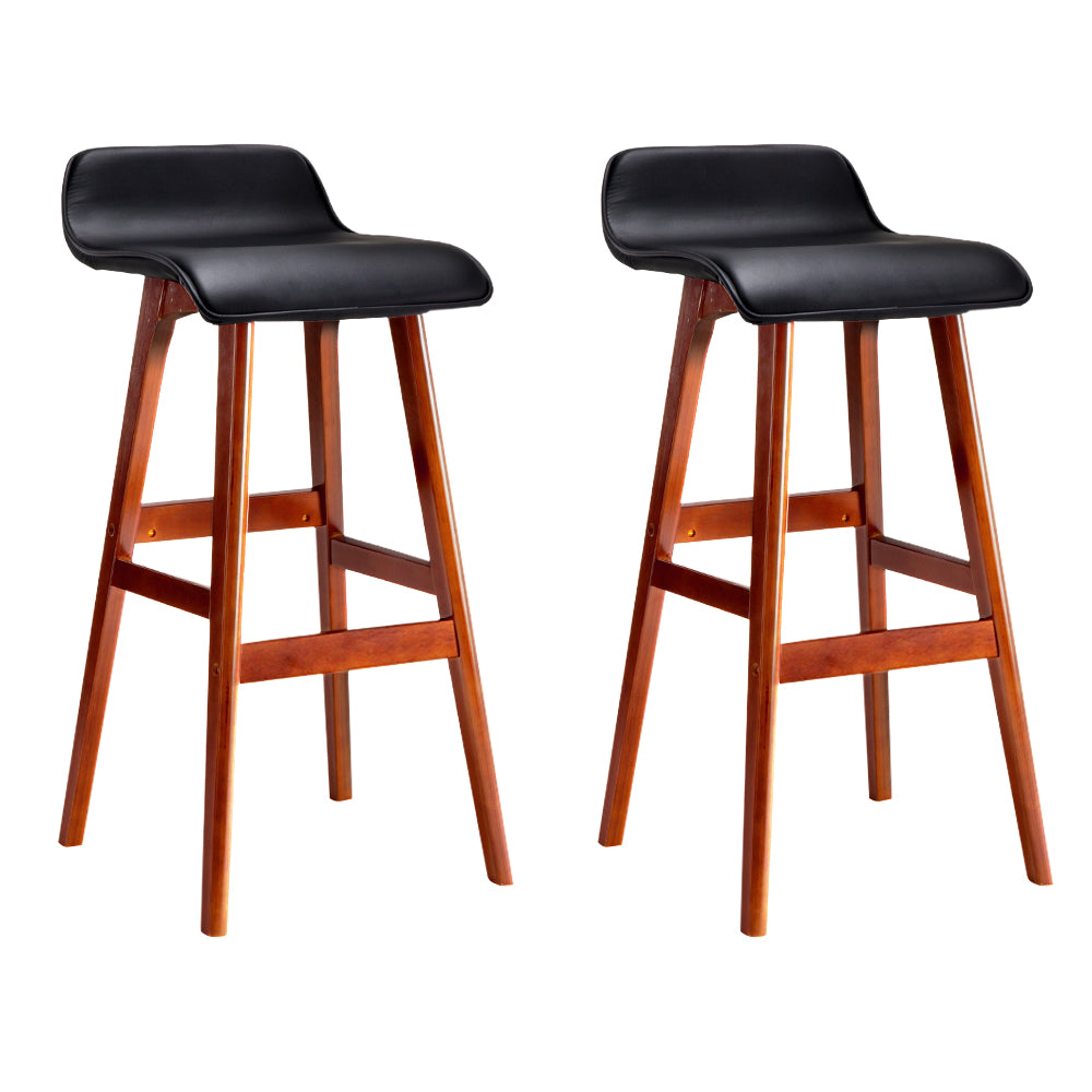 Two black leather bar stools with wooden legs on a white background